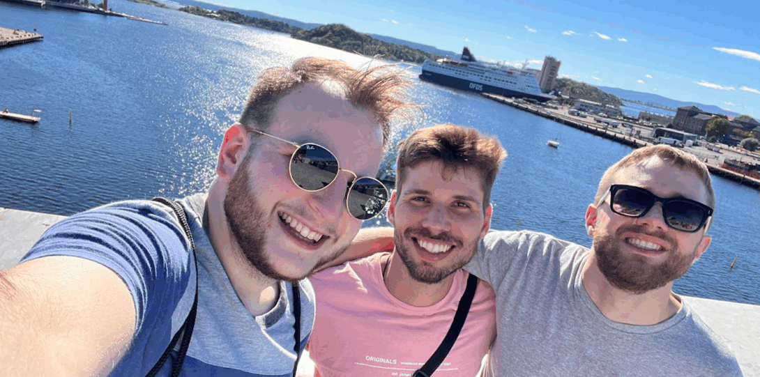 Sam, Luis, and Ian take a selfie by the water in Oslo during the 2023 Resisforce meeting in Norway